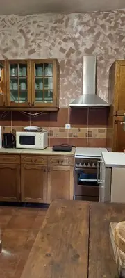 a kitchen with wooden cabinets and a stove top oven at Golemi kamik Pirot in Pirot
