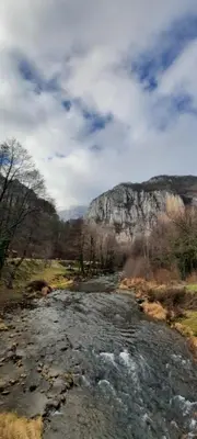 a river in a field with a mountain in the background at Golemi kamik Pirot in Pirot
