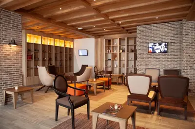 a restaurant with chairs and tables and a brick wall at Zupa Deluxe Kopaonik in Kopaonik
