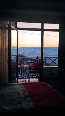 a room with a bed and a balcony with a view at Apartman Sunset Milmari Kopaonik M10 in Kopaonik