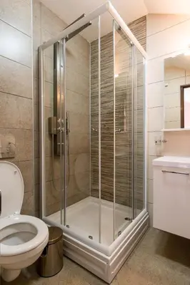 a shower stall in a bathroom with a toilet at Prenoćište HRAST in Paraćin