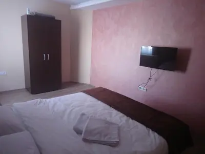 a bedroom with a bed and a flat screen tv at Prenoćište HRAST in Paraćin