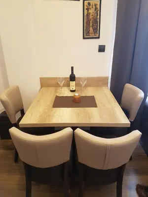 a wooden table with a bottle of wine and two glasses at Apartment M1 MEGI, Milmari Resort in Kopaonik
