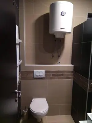 a bathroom with a toilet and a light on the wall at Apartment M1 MEGI, Milmari Resort in Kopaonik