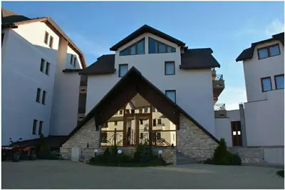 a large white building with a triangular roof at Apartment M1 MEGI, Milmari Resort in Kopaonik
