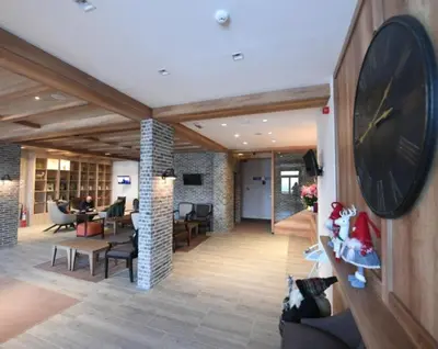 a large clock on a wall in a lobby at Apartmani ŽUPA in Kopaonik