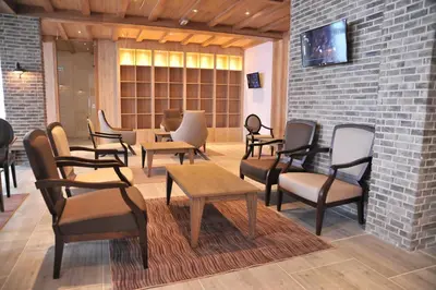 a waiting room with chairs and tables and a brick wall at Apartmani ŽUPA in Kopaonik