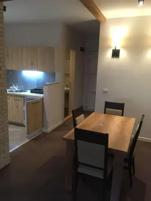 a kitchen and dining room with a wooden table and chairs at Apartmani ŽUPA in Kopaonik