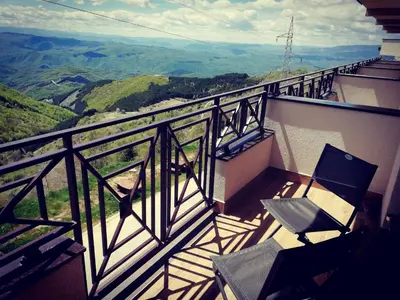 a balcony with two chairs and a view of the mountains at Katia М14 Milmari Resort in Kopaonik