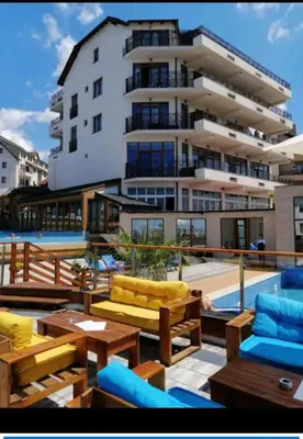 a balcony with furniture and a large building at Katia М14 Milmari Resort in Kopaonik