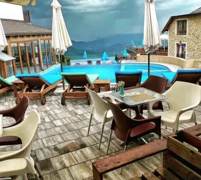 a patio with a pool and tables and chairs at Katia М14 Milmari Resort in Kopaonik