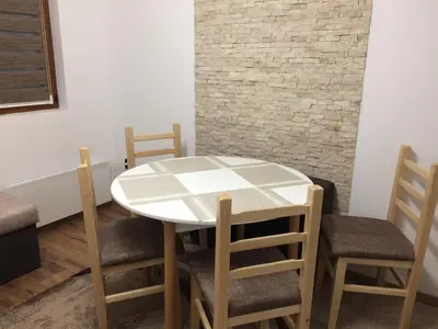 a table and chairs in a room with a brick wall at Apartment Lazic vila Suri in Kopaonik
