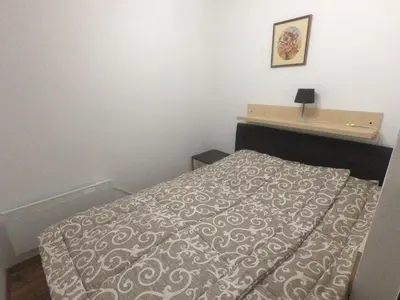 a small bedroom with a bed and a table at Apartment Lazic vila Suri in Kopaonik