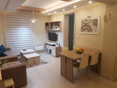 a living room with a table and a living room with a couch at LUX Apartman B1 Milmari in Kopaonik