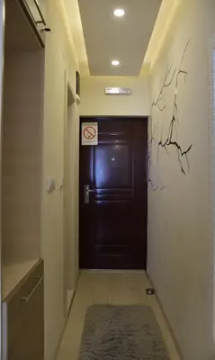 a door in a hallway with a rug in front of it at LUX Apartman B1 Milmari in Kopaonik
