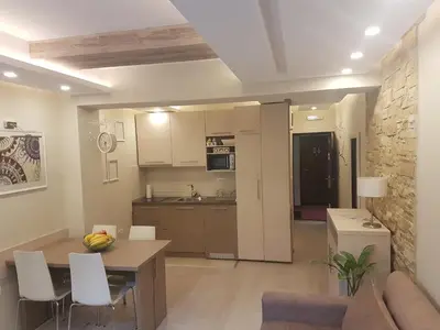 a kitchen and living room with a table and chairs at LUX Apartman B1 Milmari in Kopaonik