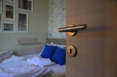 a room with a door with a bed with blue pillows at LUX Apartman B1 Milmari in Kopaonik