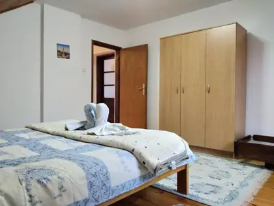 a bedroom with a bed and a wooden cabinet at Sanja Accomodation in Soko Banja