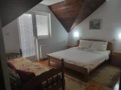 a bedroom with two beds and two windows at Sanja Accomodation in Soko Banja
