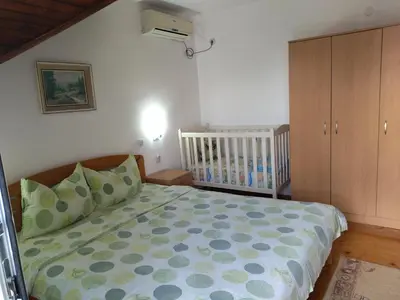 a bedroom with a bed and a crib in it at Sanja Accomodation in Soko Banja