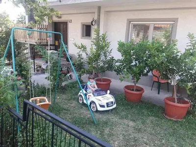 a child in a toy car in a yard at Sanja Accomodation in Soko Banja