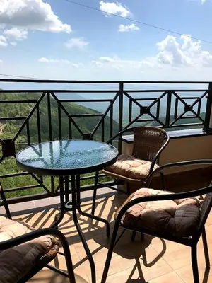 a glass table and two chairs on a balcony at Milmari M18 Kopaonik in Kopaonik