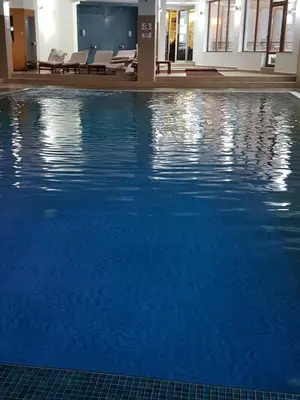 a swimming pool with blue water in a building at Milmari M18 Kopaonik in Kopaonik