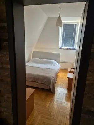a small bedroom with a bed and a window at kraljevski apartman in Kopaonik