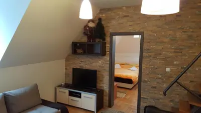 a living room with a television and a bedroom at kraljevski apartman in Kopaonik
