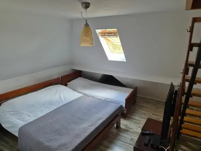 a small room with two beds and a window at kraljevski apartman in Kopaonik