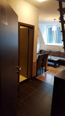 a door leading into a living room with a table and chairs at kraljevski apartman in Kopaonik