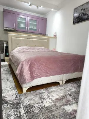 a bedroom with a large bed with purple cabinets at Alex 2 apartman in Vrnjačka Banja