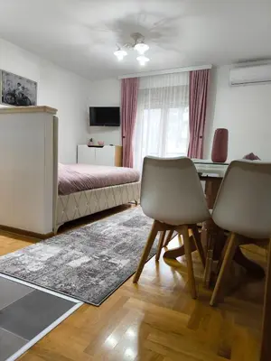 a bedroom with a bed and a table and chairs at Alex 2 apartman in Vrnjačka Banja