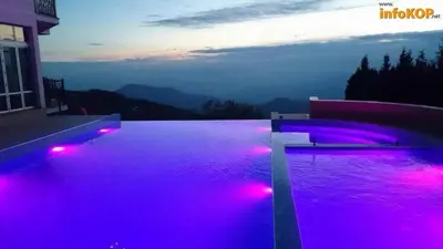 a swimming pool with purple lights on a house at Exclusive Apartment B7 Milmari Resort in Kopaonik