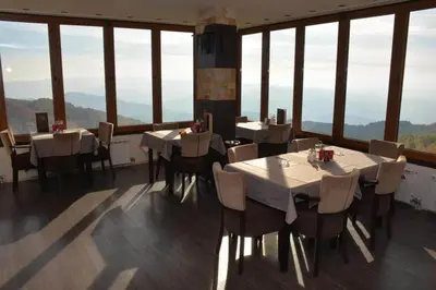 a restaurant with tables and chairs and large windows at Exclusive Apartment B7 Milmari Resort in Kopaonik