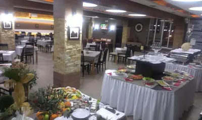 a dining room with tables with plates of food at Exclusive Apartment B7 Milmari Resort in Kopaonik