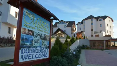 a sign in front of a building with houses at Exclusive Apartment B7 Milmari Resort in Kopaonik