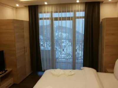 a bedroom with a white bed and a large window at Apartment Simonida - Milmari M3 in Kopaonik