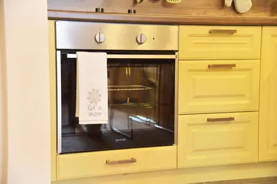 a yellow kitchen with an oven with a sign on it at Apartment Mint in Kopaonik
