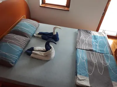 two swans are sitting on a bed with pillows at Apartment Hedonic in Vrnjačka Banja
