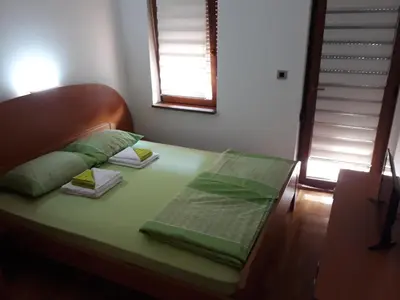 a bed with green sheets and pillows on it at Apartment Hedonic in Vrnjačka Banja