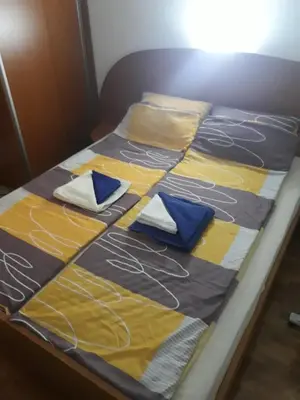 a bed with colorful blankets and pillows on it at Apartment Hedonic in Vrnjačka Banja