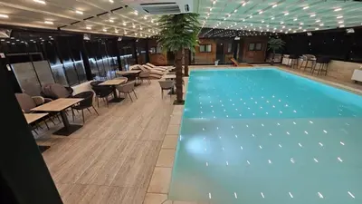 a swimming pool with tables and chairs in a building at Relax Apartment in Vrnjačka Banja