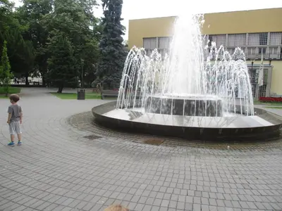 a young boy standing in front of a fountain at Relax Apartment in Vrnjačka Banja