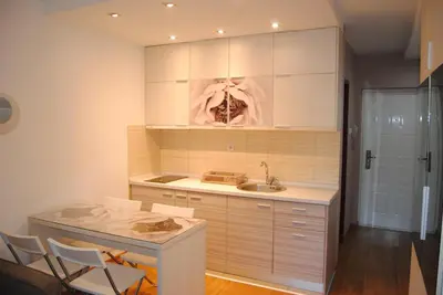 a kitchen with a sink and a table and chairs at Relax Apartment in Vrnjačka Banja