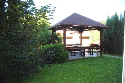 a gazebo with a picnic table in a yard at Relax Apartment in Vrnjačka Banja