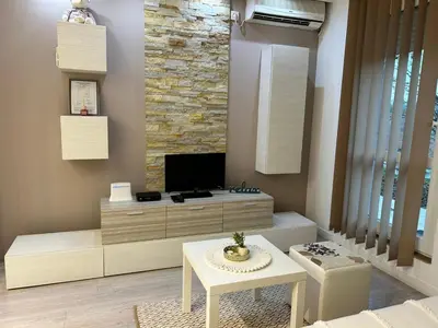 a living room with a tv and a table at Relax Apartment in Vrnjačka Banja