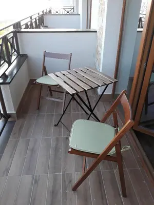 a wooden table and a chair on a balcony at Shining Apartment Milmari M11 in Kopaonik
