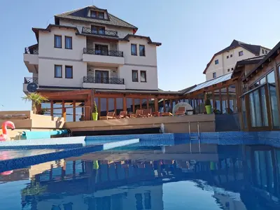 a hotel with a swimming pool in front of a building at Shining Apartment Milmari M11 in Kopaonik