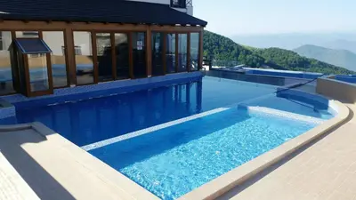a large blue swimming pool with a house at Shining Apartment Milmari M11 in Kopaonik
